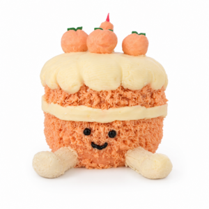 Smiling peach-colored celebration cake with fondant peaches on a clean white background.